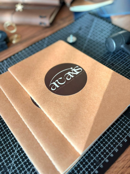 Close-up of faux leather journal cover with brand emblem — Arc and Axis